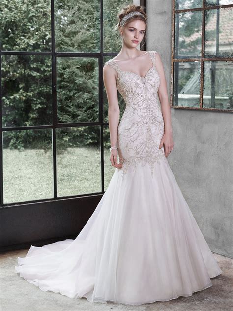 Bijou bridal - Style: Monarch LeighDescription: This lovely modest A-line wedding dress features a soft lace bodice, with bead embroidered lace accenting the waist and sleeves. Complete with a scoop neckline and a soft tulle skirt. …